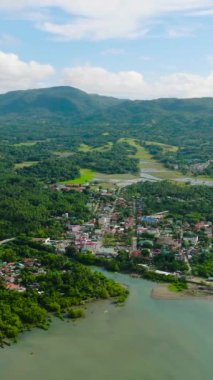 Looc Poblacion 'un sahil ve rıhtımdaki yerleşim bölgesinin insansız hava aracı görüntüsü. Tablolar Adası. Romblon, Filipinler. Dikey görünüm.