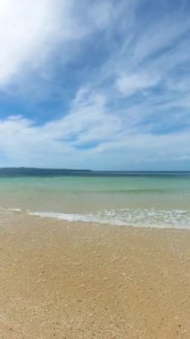 Sahilin iç kısımlarında açık dalgalar ve güneş yansıması olan kumlar. Santa Fe, Tablo Adası. Romblon, Filipinler. Dikey görünüm.