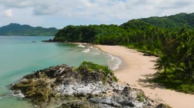 Kayaların üzerinde okyanus dalgaları ve sahil şeridi kumsalı. Duli Sahili. El Nido, Palawan. Filipinler.