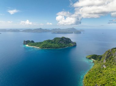 Mavi denizle çevrili helikopter adası. Mavi gökyüzü ve bulutlar. El Nido, Palawan. Filipinler.