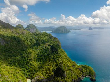 Cadlao Adası 'ndaki yeşil ağaçlar mavi denizle çevrili. El Nido, Palawan. Filipinler.
