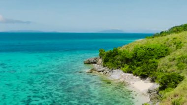 Cobrador Adası 'ndaki kayalık kıyılarda turkuaz su ve mercanlar. Romblon, Filipinler.