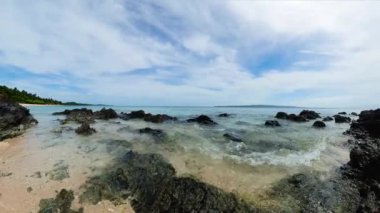 Kıyıdaki kayaların üzerinden okyanus dalgaları süzülüyor. Santa Fe, Tablo Adası. Romblon, Filipinler.