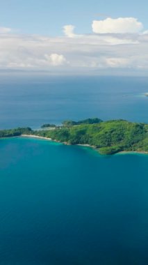 Plajı ve mavi denizi olan tropik adalar. Mavi gökyüzü ve bulutlar. Romblon, Filipinler. Dikey görünüm.