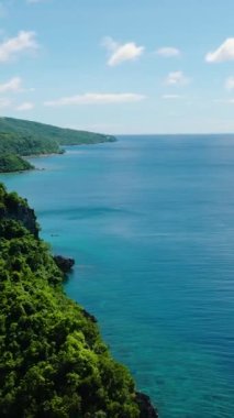 Tropik plaj ve güneş yansımalı mavi deniz. Mavi gökyüzü ve bulutlar. Romblon, Romblon. Filipinler. Dikey görünüm.