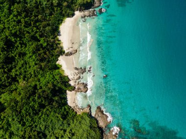 El Nido, Filipinler 'de kumlu sahildeki deniz dalgalarının ve kıyılardaki kayaların en üst görüntüsü.