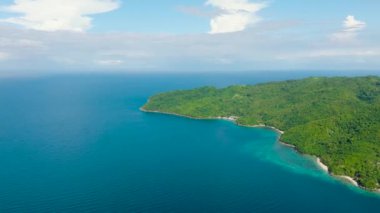 Romblon Adası üzerindeki yeşil ağaçlar Mavi Deniz ile çevrilidir. Mavi gökyüzü ve bulutlar. Filipinler.