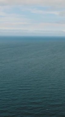 Dalgalarla açık deniz yüzeyi. Mavi gökyüzü ve bulutlar. San Jose. Romblon, Filipinler. Dikey görünüm.