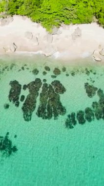 Beyaz kumsal ve Carabao Adası 'nda okyanus dalgaları olan kayalar. San Jose, Romblon. Filipinler. Dikey görünüm.