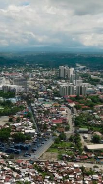Şehir manzarası, modern binalar ve küçük evler. Cagayan de Oro. Mindanao, Filipinler. Şehir manzarası. Dikey video.
