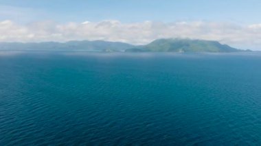 Mavi gökyüzü ve bulutların altındaki Mavi Deniz yüzeyinin drone görüntüsü. Romblon, Filipinler.