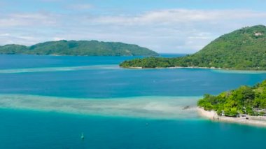 Mavi denizde ve sahilde turkuaz suyu olan adanın insansız hava aracı görüntüsü. Gargantos Plaj Tatil Köyü. Romblon, Filipinler.