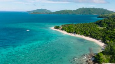 Turkuaz deniz suyu ve dalgalı beyaz kumsal. Logbon Adası. Romblon, Filipinler.
