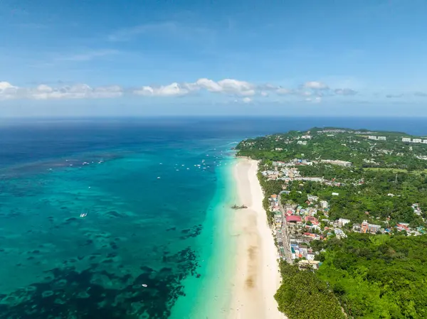 Turist tekneleri turkuaz sularda yüzüyor. Boracay, Filipinler 'deki beyaz kumsal.