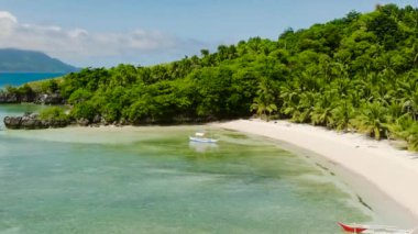 Kobrador Adası 'ndaki beyaz kumlu sahilde, krampon suyunun üzerinde yüzen tekneler. Romblon, Filipinler.