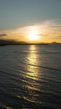 Güzel günbatımı yolu olan güzel okyanus dalgaları. Mindanao, Filipinler. Dikey görünüm. Seyahat kavramı.