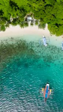 Pasandigan Koyu 'nda bir grup tekne. Yeşil deniz suyunun üzerindeki güneş yansıması. Cadlao Adası. El Nido. Palawan, Filipinler. Dikey görünüm.