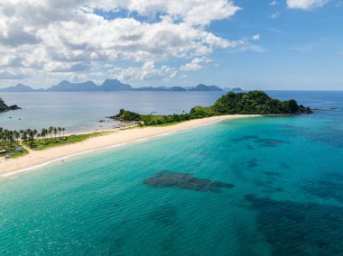 Kumdaki dalgalar ve turkuaz berrak deniz suyu. Nacpan Sahili. El Nido, Palawan. Filipinler.