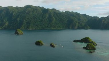 Mavi denizle çevrili tropikal adalar ve Islets tur botları. Mavi gökyüzü ve bulutlar. Coron, Palawan, Filipinler.