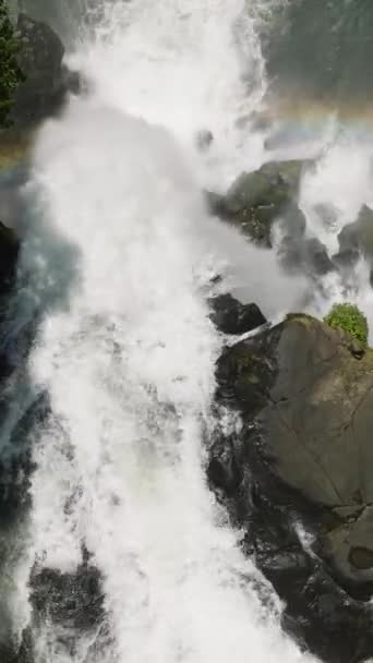 高い岩からの滝の流れの上の虹は 流れに分裂し 間違いを生み出します リムンダンフォールズ フィリピン ミンダナオ 垂直ビュー — ストック動画