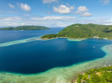 Mavi denizde ve sahilde turkuaz suyu olan adanın insansız hava aracı görüntüsü. Gargantos Plaj Tatil Köyü. Romblon, Filipinler.