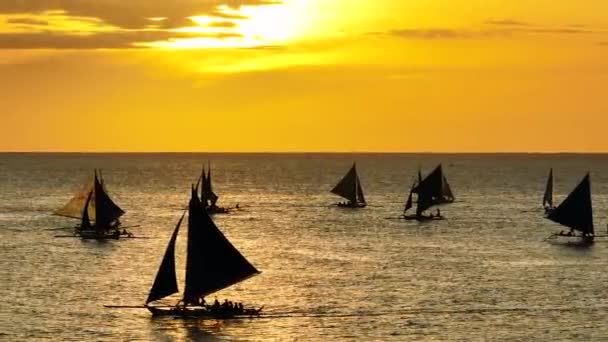 セーリングボートと海の上の黄色いオレンジ色の空と日没 ボラカイ フィリピン — ストック動画