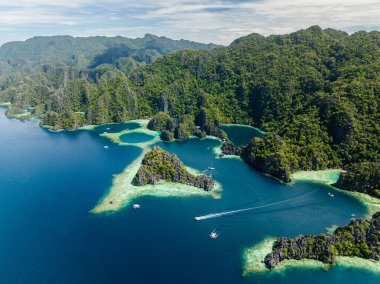 Mavi denizde tur tekneleri olan tropik adalar. İkiz Göl. Coron, Palawan. Filipinler.