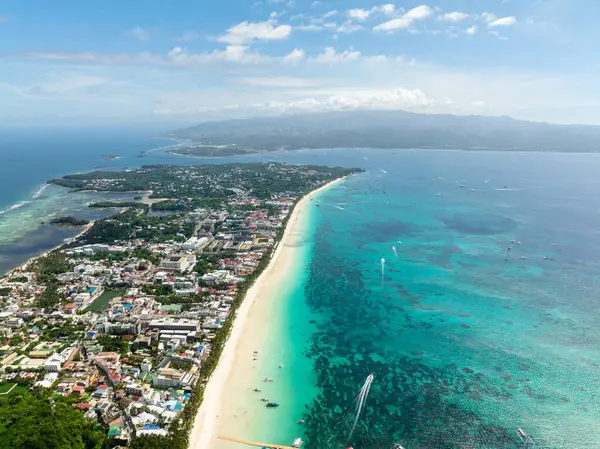 Boracay Adası 'ndaki temiz su ve Beyaz Kum Sahili mavi gökyüzü ve bulutların altında. Filipinler.