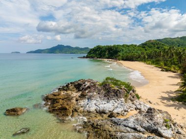 Turkuaz deniz suyu ve Duli Sahili 'nde kayalar ve kumlar üzerinde dalgalar. El Nido, Filipinler.