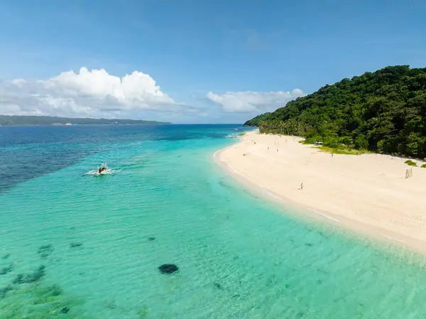 Hindistan cevizi ağaçları ve beyaz kumlarda okyanus dalgaları olan bir sahil. Puka Deniz Kabuğu Sahili. Boracay Adası. Filipinler.