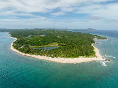 Okyanus dalgaları ve turkuaz deniz suyuyla beyaz kumlu sahil manzarası. Santa Fe, Tablas, Romblon. Filipinler.