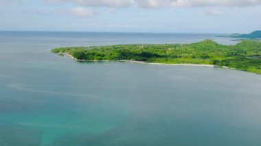 Turkuaz deniz suyuyla çevrili yeşil bitkilerle tropikal adanın insansız hava aracı görüntüsü. Looc, Tablas Adası. Romblon, Filipinler.