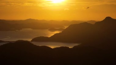 Adaların üzerinde turuncu gökyüzü. Filipinlerde Günbatımı.
