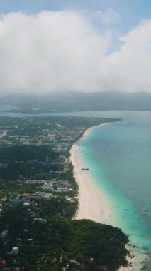 Turkuvaz deniz suları ve dalgalar üzerinde tekneleri olan tropik plajlar. Boracay, Filipinler. Dikey görünüm.