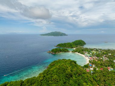 Kıyı bölgesinde evleri ve balıkçı tekneleri olan tropik bir ada. Alad Adası. Romblon, Filipinler.