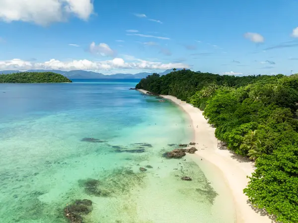 Beyaz kumlu sahilde, berrak okyanus dalgalarıyla Tiamban Sahili 'nin üzerinde uçuyor. Romblon Adası. Romblon, Filipinler.