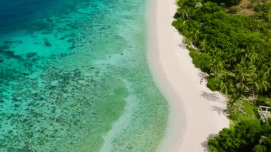 Kumlu sahil bölgesindeki mavi deniz ve turkuaz deniz suyunun en üst görüntüsü. Cobrador Adası. Romblon, Filipinler.