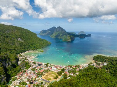 El Nido 'daki şehrin havadan görüntüsü. Turkuaz açık deniz suyunda tekneler. Filipinler.