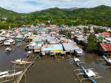 Coron, Palawan 'da kıyı şeridindeki Stilt evleri ve botlar. Filipinler.