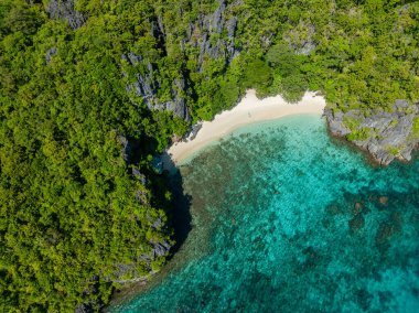 White sand and turquoise clear water with corals in Serenity beach. Cadlao Island. El Nido, Palawan. Philippines. clipart
