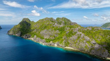 Tropikal kıyı şeridindeki mavi denizde tekneler. Matinloc Adası. El Nido, Filipinler.