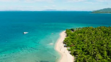 Temiz deniz suyuyla beyaz sahilin insansız hava aracı görüntüsü. Mavi gökyüzü ve bulutlar. Logbon Adası. Romblon, Filipinler.