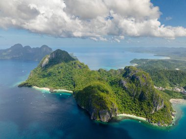 El Nido 'da beyaz kumlu tropik plajlar. Mavi denizi aşan tekneler. Filipinler.