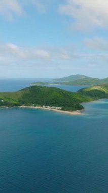 Beyaz kum ve mavi denizi olan tropik plajlar. Mavi gökyüzü ve bulutlar. Romblon, Filipinler. Dikey görünüm.