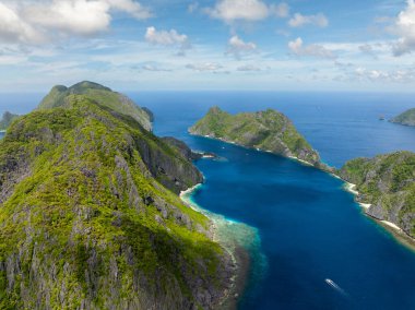 Tapiutan Adası ve Matinloc Adası mavi deniz üzerinde boa ile. El Nido, Palawan. Filipinler.