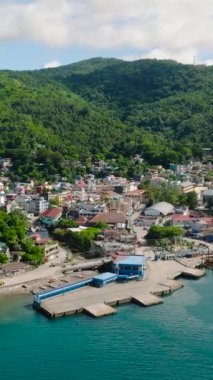 Limanı olan sahil, evleri olan şehir. Romblon Adası 'ndaki mavi denizin üzerinde feribot. Romblon, Filipinler. Dikey görünüm.