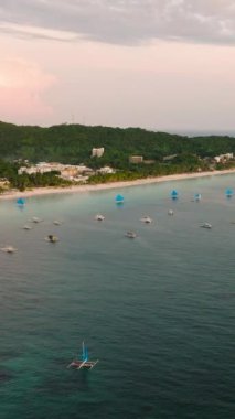 Paraw yelkenli teknelerle White Beach 'in havadan görünüşü, oteller ve turkuaz deniz suyu. Boracay, Filipinler. Dikey görünüm.