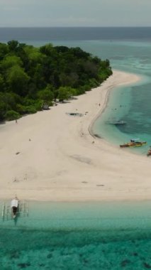 Mantigue Adası 'nda kumlu bir sahil, tekneli bir sahil. Camiguin, Filipinler. Seyahat güzergahı. Dikey video.