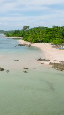 Okyanus dalgaları tekneyle kumlu sahile çarpıyor. Santa Fe, Tablas, Romblon. Filipinler. Dikey görünüm.