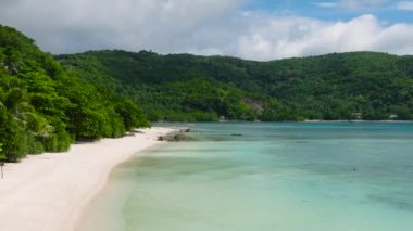 Teknesi ve dalgaları olan beyaz kumsal. Mavi gökyüzü ve bulutlar. Romblon, Filipinler.